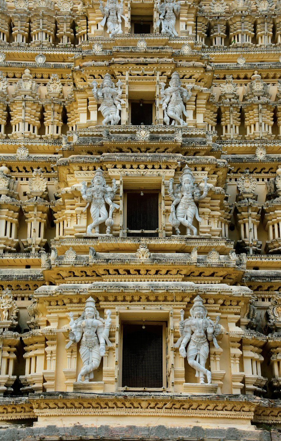 Intricately carved stone statues on an ancient Indian temple tower.