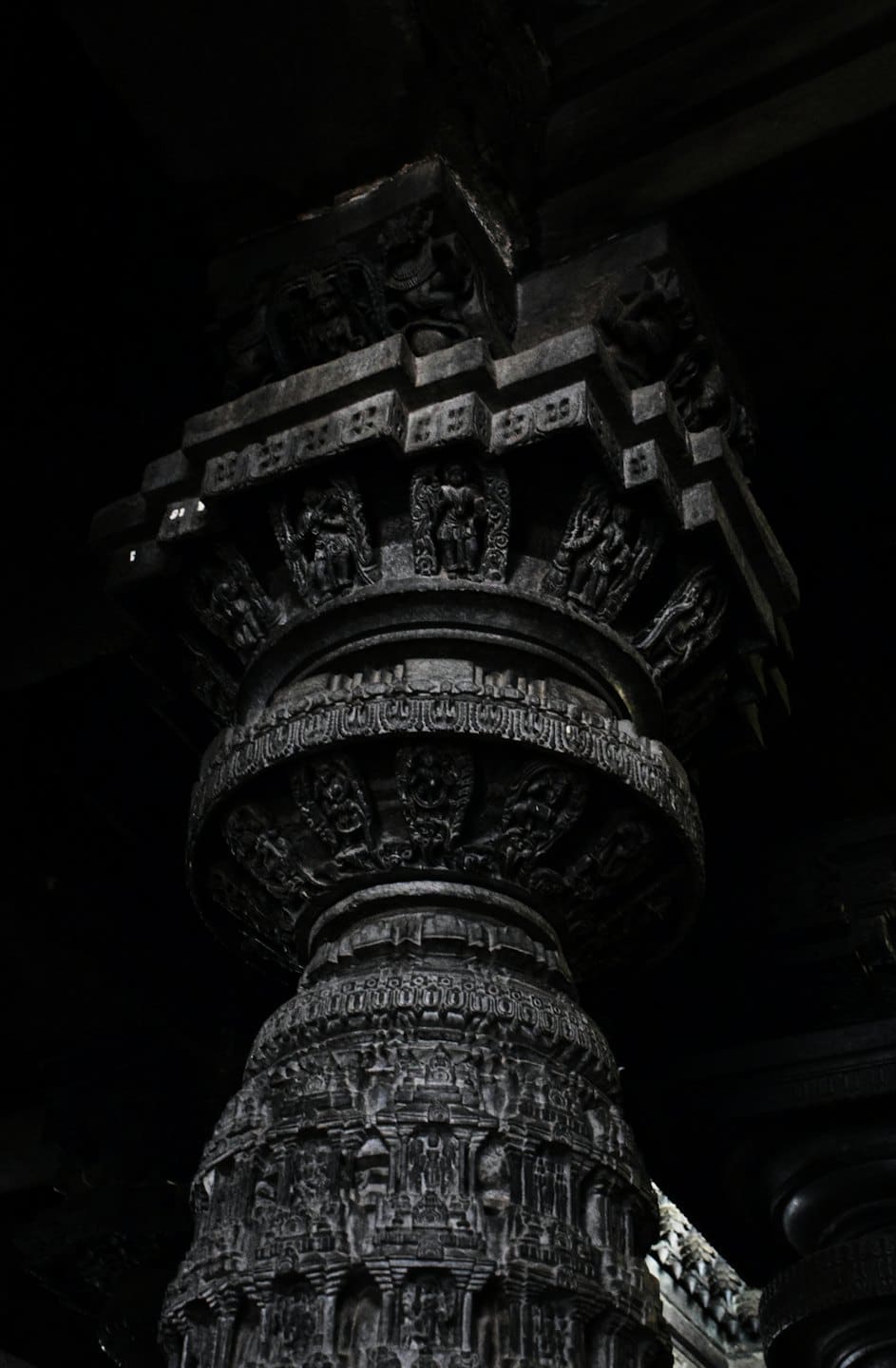 Intricately carved stone pillar inside an ancient historic temple.