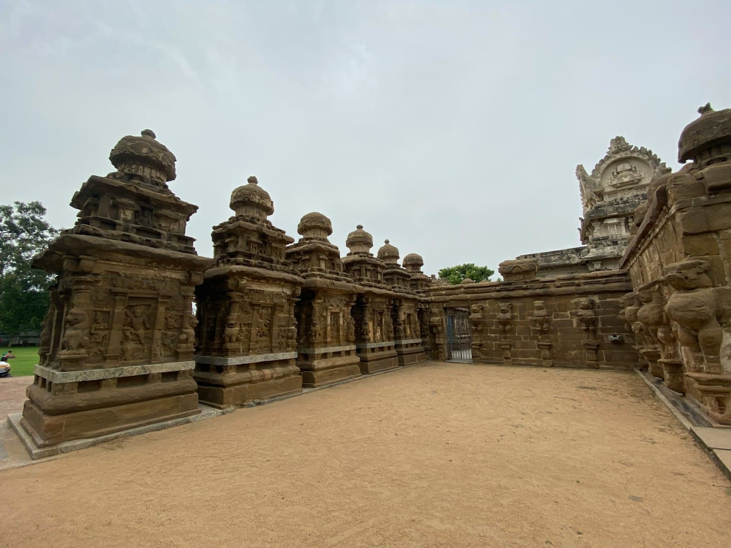 Ornately carved stone shrines and lion sculptures at a temple.