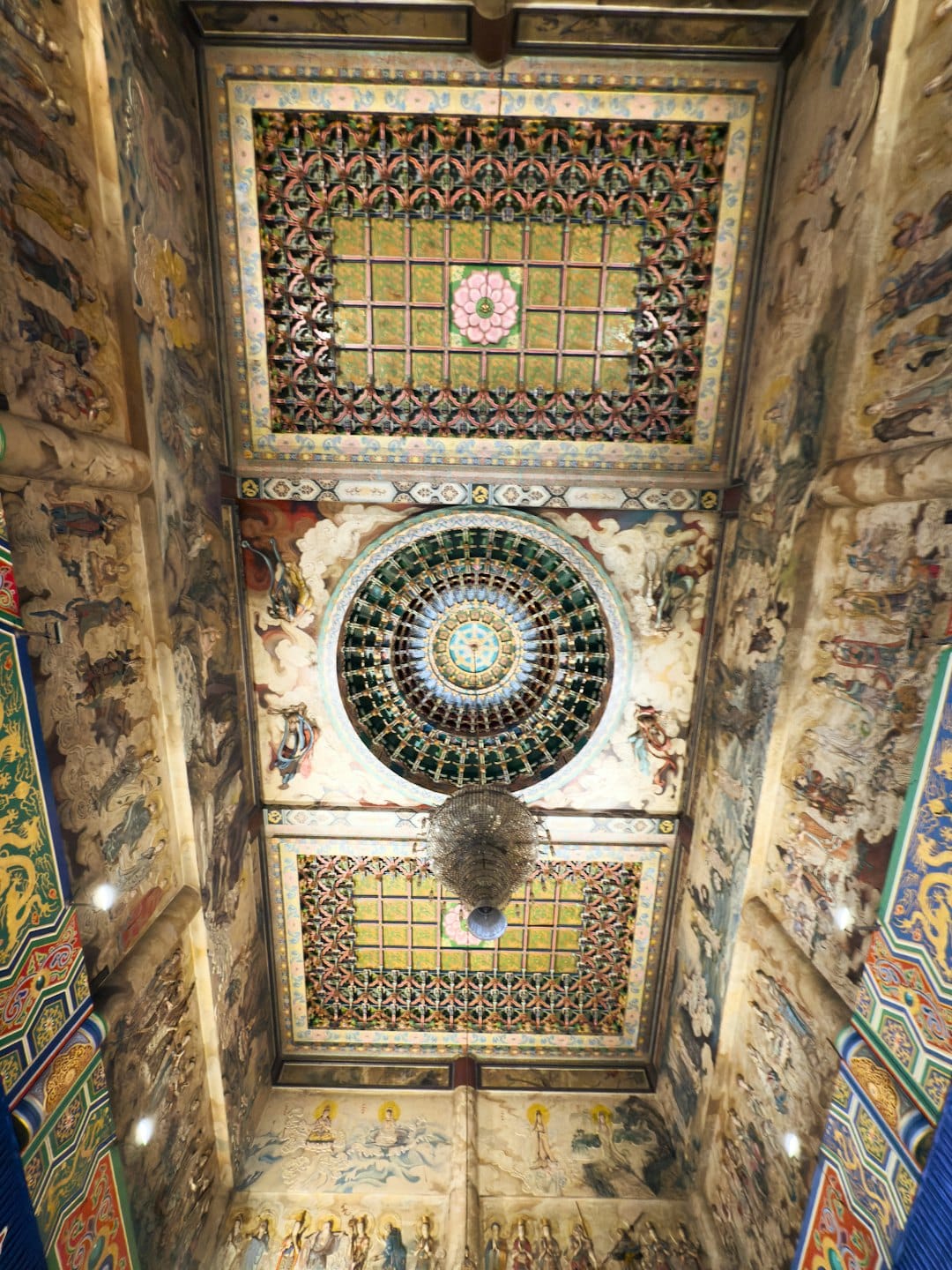 Intricate wood carvings and murals decorate the temple ceiling.