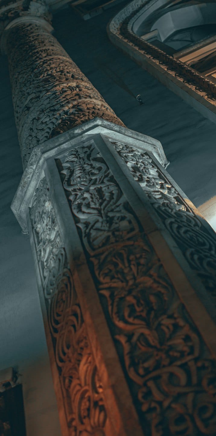 Detailed stone pillar carved with intricate geometric and organic patterns.